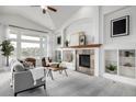 Spacious living room with a stone fireplace, built-in bookshelves and large windows at 8802 E 148Th Ln, Thornton, CO 80602