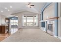 Inviting living room featuring vaulted ceilings, large windows, a ceiling fan, and a fireplace at 8802 E 148Th Ln, Thornton, CO 80602