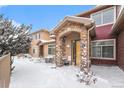 Front view of townhome showcasing snowy landscaping and stone details at 8551 Gold Peak Dr # B, Highlands Ranch, CO 80130