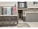 Close up on Front Entrance featuring stone detail and American flag at 6827 Leilani Ln, Castle Rock, CO 80108