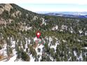 House nestled in a snowy wooded mountainside at 8919 Hillview Rd, Morrison, CO 80465