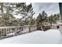 Wooden deck overlooking a snowy wooded area at 8919 Hillview Rd, Morrison, CO 80465