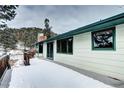 Back exterior of the house showing deck and snowy landscape at 8919 Hillview Rd, Morrison, CO 80465