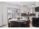 Inviting dining area with a slider door to the backyard, modern lighting, and white cabinets at 15123 E Wesley Ave, Aurora, CO 80014