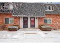 Charming brick townhouse with well-maintained landscaping and snowy winter scenery at 15123 E Wesley Ave, Aurora, CO 80014