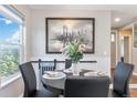 Cozy dining area with wainscoting, a round table set for four, and a large window with scenic views at 2645 S Xanadu Way # D, Aurora, CO 80014