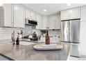Modern kitchen featuring stainless steel appliances, white cabinets and gray countertops at 2645 S Xanadu Way # D, Aurora, CO 80014