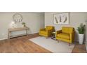 Cozy staged living room with two yellow armchairs and matching decor at 15650 E Eldorado Dr, Aurora, CO 80013