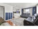 Open living room with hardwood floors, a dark leather couch, and a view into the kitchen at 1381 Mariposa Dr, Denver, CO 80221