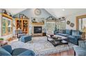Cozy living room with a stone fireplace, vaulted ceilings, many windows, and comfortable furnishings at 30206 Telluride Ln, Evergreen, CO 80439