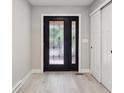 Home entryway featuring decorative glass front door, white trim, modern gray walls and closet at 10506 Brown Fox Trl, Littleton, CO 80125