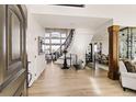 Bright foyer with wood floors, curved staircase, chandelier, and views into other living spaces at 12457 Topaz Vista Way, Castle Pines, CO 80108