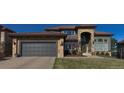 Stunning home with a two-car garage, stone accents, archway entrance and red tile roof at 12457 Topaz Vista Way, Castle Pines, CO 80108