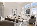 Cozy living room with large windows, high ceiling, stylish furniture, and plenty of natural light at 12457 Topaz Vista Way, Castle Pines, CO 80108