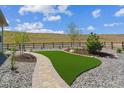 Beautiful backyard featuring an attractive artificial turf lawn, stone walkway and wooden fence at 547 Scrubjay Cir, Castle Rock, CO 80104