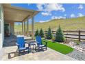 Relaxing outdoor patio with comfortable blue chairs, a grassy area, and scenic views at 547 Scrubjay Cir, Castle Rock, CO 80104