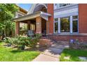 Inviting covered front porch with brick columns and cozy seating area, perfect for relaxing outdoors at 1160 York St, Denver, CO 80206