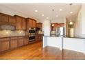 Bright kitchen with wooden floors, cabinets, stainless steel appliances, and granite countertops at 15625 Carob Cir, Parker, CO 80134