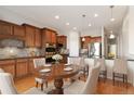 Eat-in kitchen features stainless appliances, granite countertops, and wood cabinetry at 15625 Carob Cir, Parker, CO 80134