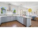 Bright kitchen featuring blue cabinets, stainless steel appliances, and an open layout connected to the dining area at 4958 Valentia Ct, Denver, CO 80238