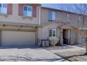 A townhome's front exterior features a two-car garage and inviting front porch at 10588 Parkington Ln # 39A, Highlands Ranch, CO 80126