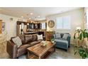 Open-concept living room with a comfortable sofa, accent chair, and adjacent kitchen with modern appliances at 1640 Aspen Meadows Cir, Federal Heights, CO 80260