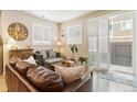 Comfortable living room with a large sofa, accent chair, and bright natural light from a sliding glass door at 1640 Aspen Meadows Cir, Federal Heights, CO 80260