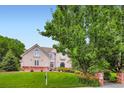 Two-story home with a well-manicured lawn, mature trees, garden, and brick mailbox at 7355 Nile St, Arvada, CO 80007