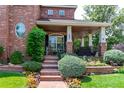 Charming front porch with brick stairs and beautiful landscaping at 693 Syracuse St, Denver, CO 80230