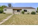Charming single-story home with a well-manicured lawn with a classic covered front porch and large windows at 107 S Windsor Dr, Denver, CO 80219