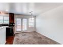 Bright dining area featuring neutral carpet and a sliding glass door to the deck at 19043 E 58Th Ave, Denver, CO 80249