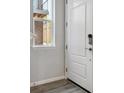 Bright entryway featuring a white front door, wood floors and a window at 457 Interlocken Blvd # 106, Broomfield, CO 80021
