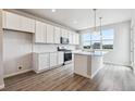 Open concept kitchen featuring gray wood flooring, large windows and stainless steel appliances at 457 Interlocken Blvd # 106, Broomfield, CO 80021