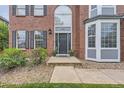 Inviting front entrance featuring a stylish door, a decorative archway, and well-maintained landscaping at 9458 S Hackberry Ln, Highlands Ranch, CO 80129