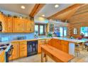Warm, rustic kitchen with wood beams, cabinets, and tile floors, creating a cozy culinary space at 812 High Point Dr, Breckenridge, CO 80424