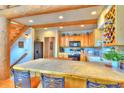 Spacious kitchen with tile countertops, wooden cabinetry, breakfast bar, and adjacent staircase, perfect for gatherings at 812 High Point Dr, Breckenridge, CO 80424