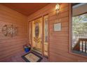 Close-up of the front door with decorative glass, a 'Welcome' mat, and exterior wall decor at 767 Tenderfoot Dr, Larkspur, CO 80118