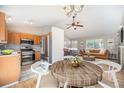 Open concept kitchen and living room with stainless steel appliances, hardwood floors, and plenty of natural light at 9712 Adams St, Thornton, CO 80229