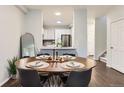 Dining area with wooden table set for four and view to the kitchen with stainless appliances at 9758 Laredo St # 1E, Commerce City, CO 80022