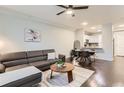 Open concept living room with view to the kitchen; features hardwood floors and modern furnishings at 9758 Laredo St # 1E, Commerce City, CO 80022