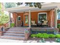 Inviting front porch with seating, brick stairs, and decorative plants and curtains at 3182 W 29Th Ave, Denver, CO 80211