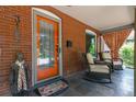Inviting front porch with an orange door, cozy seating, and decorative welcome mat at 3182 W 29Th Ave, Denver, CO 80211