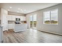 Open concept kitchen with white cabinetry and stainless appliances extends to a spacious living area at 4255 Gozzer Ranch Dr, Elizabeth, CO 80107