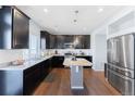 Modern kitchen with stainless steel appliances, granite countertops, and dark wood cabinetry at 10569 Racine St, Commerce City, CO 80022