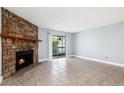 Open living area with stone fireplace, sliding glass doors, and tile floors at 18103 E Kentucky Ave # 103, Aurora, CO 80017