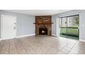 Living room featuring a stone fireplace, neutral walls, and tile flooring at 18103 E Kentucky Ave # 103, Aurora, CO 80017