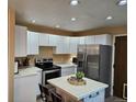 Spacious kitchen with stainless steel refrigerator and range, tile counters, and recessed lighting at 2034 S Truckee St, Aurora, CO 80013