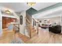 Welcoming home interior with hardwood floors, staircase, and a view into the living room and kitchen at 6382 S Zenobia Ct, Littleton, CO 80123