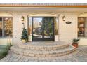 Elegant home entrance featuring double doors, classic brickwork, and stylish sconces at 6382 S Zenobia Ct, Littleton, CO 80123