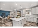 Modern kitchen with stainless steel appliances, white cabinets, and a quartz island at 1011 White Leaf Cir, Castle Rock, CO 80108